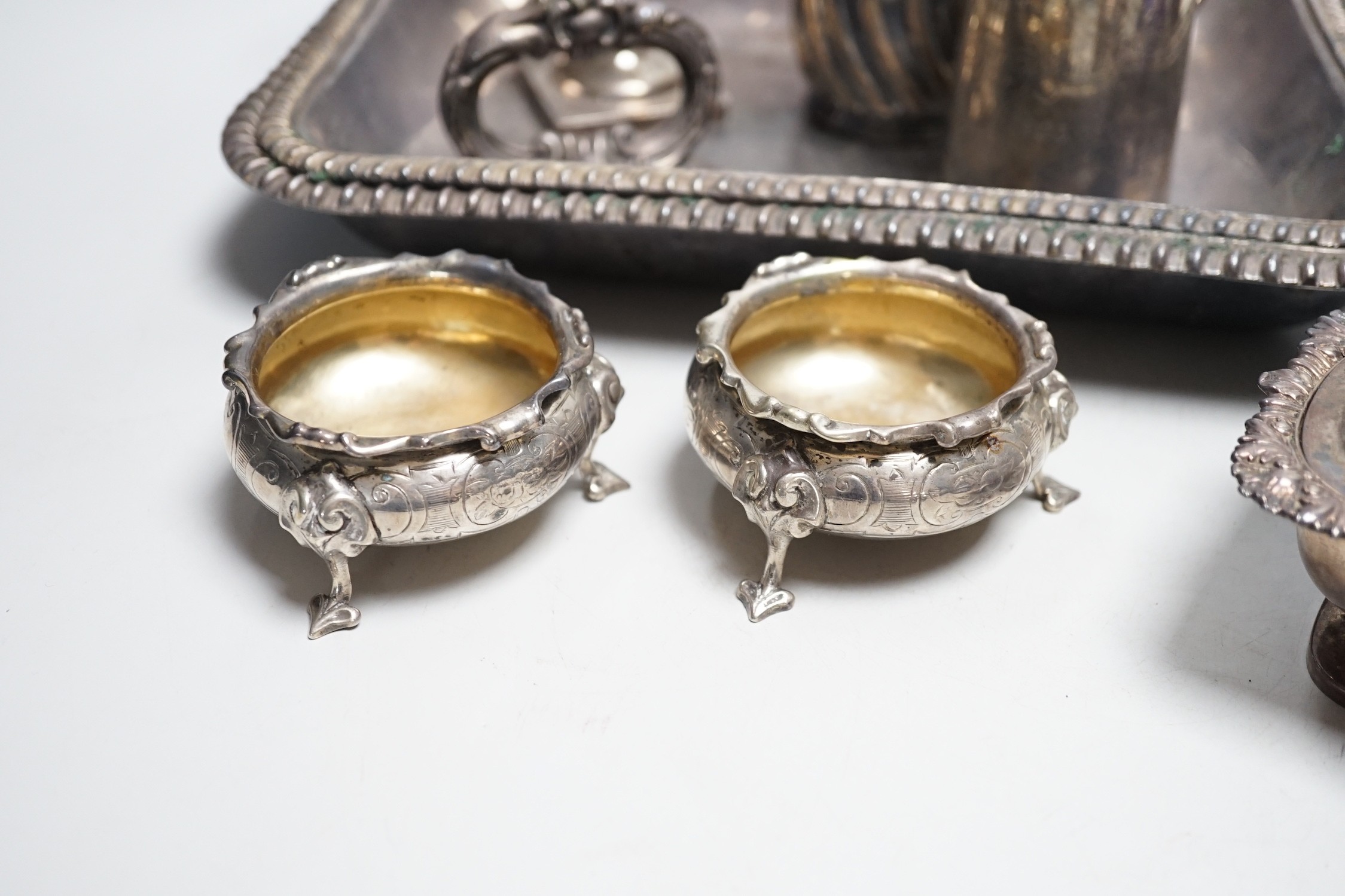 A small collection of English silver to include a pair of Victorian cauldron salts, two small beakers, a cream jug with presentation script, a George IV silver mustard pot with hinged cover, London, 1823 and a boxed chri